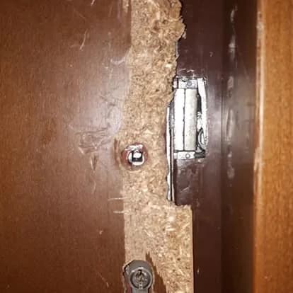 Kifeszített ajtótok a zárfogadóval, körülötte felszakadt forgácslap